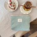 Mint green corduroy makeup bag with texture and embroidered logo on linen surface - Makeup Bag / Bean Green