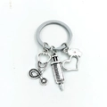 Detailed close-up of retro silver medical keychain with stethoscope and syringe charms - Style 4 (Retro Silver Stethoscope Syringe)