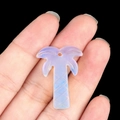 Translucent coconut tree natural crystal pendant held by hand on a dark background - Opal (Synthetic)