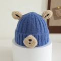 Close-up of a blue knitted baby bear hat with soft textured ears and embroidered face - 1-4 Years / Blue