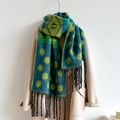 Close-up of a teal and yellow polka dot patterned scarf with dark fringe on a beige coat - WT104-1 Yellow Green