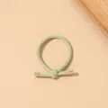 Detail of light green ribbed hair tie with elegant gold metal tips on a warm backdrop - Ribbed Knot - Metal Buckle / Fruit Green