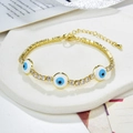 Dettaglio del bracciale dorato con zirconi e ciondoli Evil Eye blu su pietra - Oro-Occhio del Diavolo Blu/Bianco/Nero