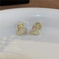 Detalle de pendientes de clip de corazón dorado con piedra rosa y almohadillas de silicona - Corazón Hueco / Clip de oreja de espiral