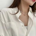 Detail view of a white freshwater pearl necklace with a golden bean pendant on a model neck - Gold Bean
