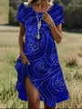 Détail d'une robe d'été bleue avec motifs à volutes blancs et fente latérale haute - Bleu saphir