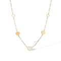Detail view of gold-plated necklace with shell-inlaid heart charms on white background - Gold