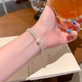 Elegante pulsera plateada de múltiples hebras para mujer con perla central blanca redonda - Pulsera Tejida de Perlas de Varias Filas