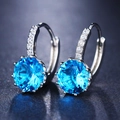 Macro detail of silver hoop earrings with round blue zircon and micro-pave setting - Ear Buckle / Lake Blue