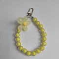 Detail of yellow acrylic beads and beige flower pendant with a silver lobster clasp - Yellow Beads Yellow Flower