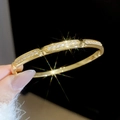 Detailed close-up of 18k gold plated horseshoe buckle bangle with pavé zircon crystals - Gold-Geometric Segmented (5#)