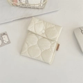 Close-up of cream quilted cosmetic pouch with snap closure and soft padded texture - Milk White