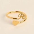 Detail eines verstellbaren Goldrings mit poliertem R-Buchstaben und Herzenden - Buchstabe R