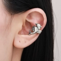 Close-up of a silver shark bite ear cuff earring worn on a model's left ear cartilage - Antique Silver (S313)