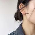 Nahaufnahme eines minimalistischen 8mm Silberkugel-Ohrsteckers am Ohr einer Frau - Klein 8mm / Silber