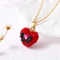 Détail du collier cœur avec cristaux rouges, nœud noir et chaîne dorée fine - Cœur Rouge Style Nœud Papillon