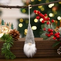 Detail of a gray knitted Christmas gnome ornament hanging with winter pine berries - Gray Type A