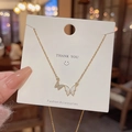 Dettaglio ravvicinato di una collana con ciondolo a farfalla dorata con strass e smalto - Oro (Doppia Farfalla Strass)