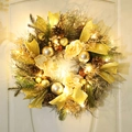 Illuminated Christmas wreath with pine cones and gold ribbons on a white wooden door - Golden Ribbon Pine Cone Snow Pine Needle Sun Wreath / With LED Lights