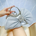 Elegant silver pleated evening bag featuring a large rhinestone bow and crystal handle - Silver