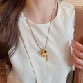 Golden horse pendant necklace with metal tassels on a brown woven cord shown on a model - 28# Necklace Gold Metal Tassel Pony Tail