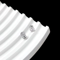 Detailed view of silver screw-back stud earrings with floral clover backings on white tray - Spiral