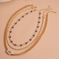 Details des dreilagigen Gold-Halsketten-Sets mit Evil-Eye-Anhänger und blauen Perlen - Halskette-Gold (3er-Set)