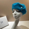 Detail view of a bright blue wool beret featuring a large pearl and golden bead accent - M (56-58cm) / Lake Blue