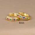 Detailed macro view of 8mm golden huggie earrings set with colorful rainbow zircon stones - 8mm / Gold