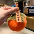 Gros plan détaillé d'un porte-clés en peluche kaki avec des feuilles vertes et un crochet - Persimmon Vie Douce