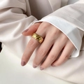 Close-up of a wide gold twisted croissant dome ring styled on a model's index finger - US 6 / Twisted Wave Style