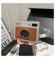 Detail shot of a vintage camera-shaped crossbody bag held by hand in a modern setting - Silver Brown