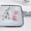 Pink translucent acetate hair claw clip with pearlescent finish on a mirror - Jelly Pink