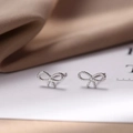 Elegant 925 silver bow stud earrings with milgrain texture on a satin display - Short Hollow Bow / Silver