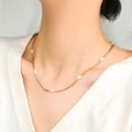 Elegante 18k vergoldete Edelstahlkette mit weißen Barockperlen an einem Model getragen - Mehrere Ovale Perlen Stil (N2027-GO)
