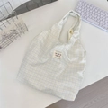 Detail of colorful embroidered logo label on a pastel checkered canvas tote bag - Soft Purple Plaid