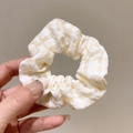 Schicker gelb-weiß karierter Organza-Haargummi in der Hand für tägliche Frisuren - Karo-Stil / Hellgelb