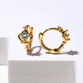 Elegante goldene Kronenohrringe mit funkelndem Zirkonia auf einem weißen Displayständer - Gold