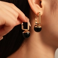 Pendientes de aro rectangulares dorados con cuentas de resina negra usados por una modelo - #14 Aguja de Acero Aro Rectangular Negro