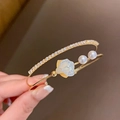 Detailed close-up of a layered gold bracelet with white pearls, floral charm and sparkling diamonds - 5# Bracelet - Gold - Flower
