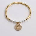 Pulsera de cuentas doradas con perla blanca y colgante de luna de circón en fondo blanco - Estilo de Colgante de Luna