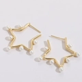 Détail de boucles d'oreilles étoiles dorées avec perles blanches sur un fond blanc pur - Pentagramme