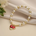 Close-up of pearl bead bracelet with golden accents and a red heart charm on satin - Simple Heart Style (E000434YS)