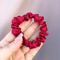 Burgundy satin silk scrunchie featuring smooth texture and elastic pleated hair tie design - Red