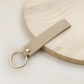 Minimalist beige leather keychain strap with a polished gold ring and metal rivet - No.12 Khaki