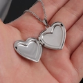 Primer plano de un relicario de corazón de acero inoxidable que se abre en la mano - 22.6*25mm / Color Acero