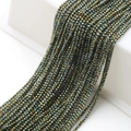 Macro view of metallic faceted glass beads for jewelry making with iridescent finish - Green Plated