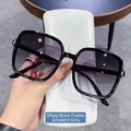 Square frame sunglasses with shiny black frames and gradient grey lenses in a hand shot - Bright Black Frame Double Gray Lens