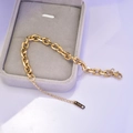 Dettaglio di bracciale a catena dorata con targhetta incisa K18 e chiusura a moschettone - Oro 18K