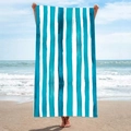 Vertical blue and white striped microfiber beach towel held by a person on a sunny beach - B15-Blue and White Vertical Stripes